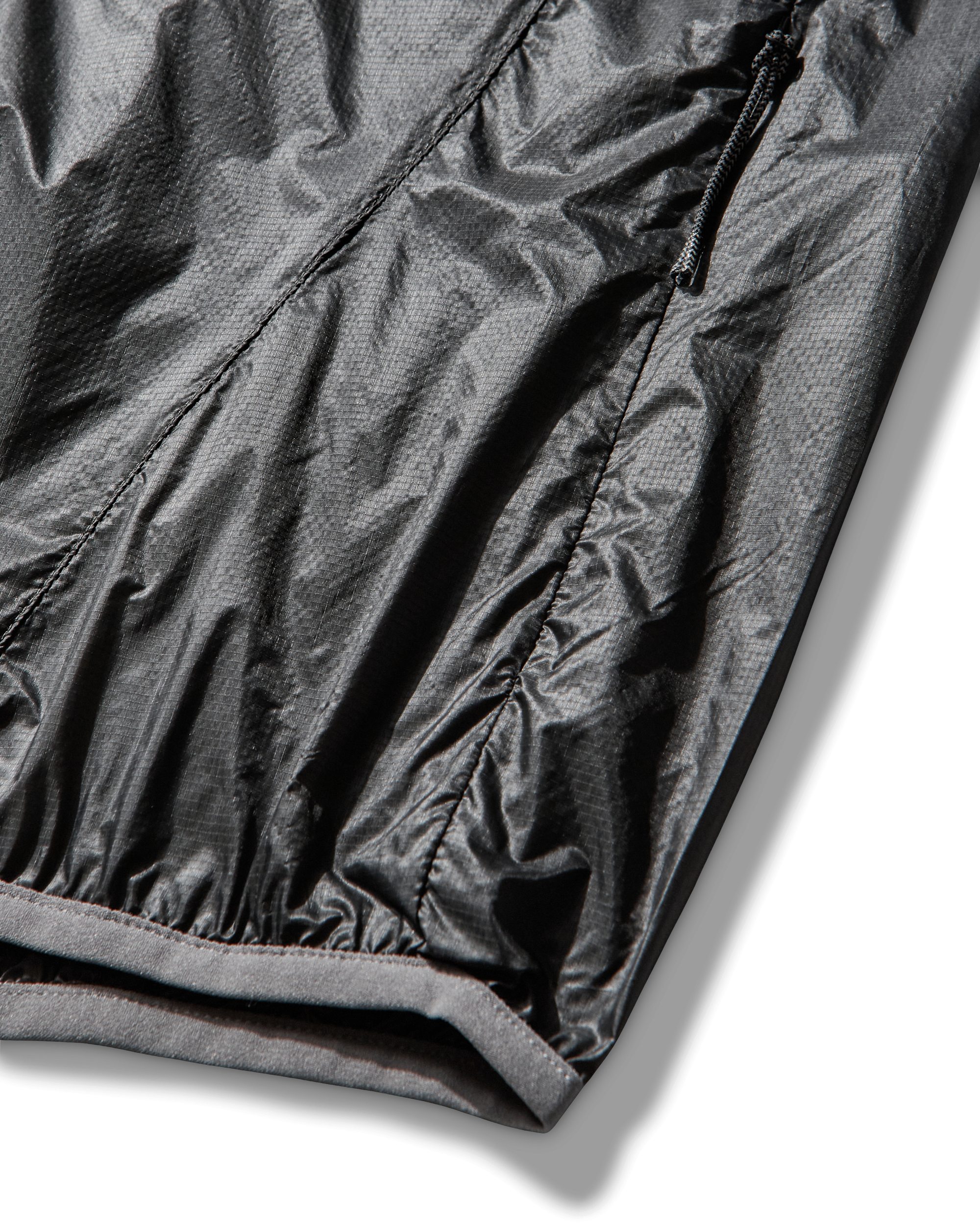 Detail of the jacket hem and sleeve cuff showing elastic finish and subtle fabric texture.