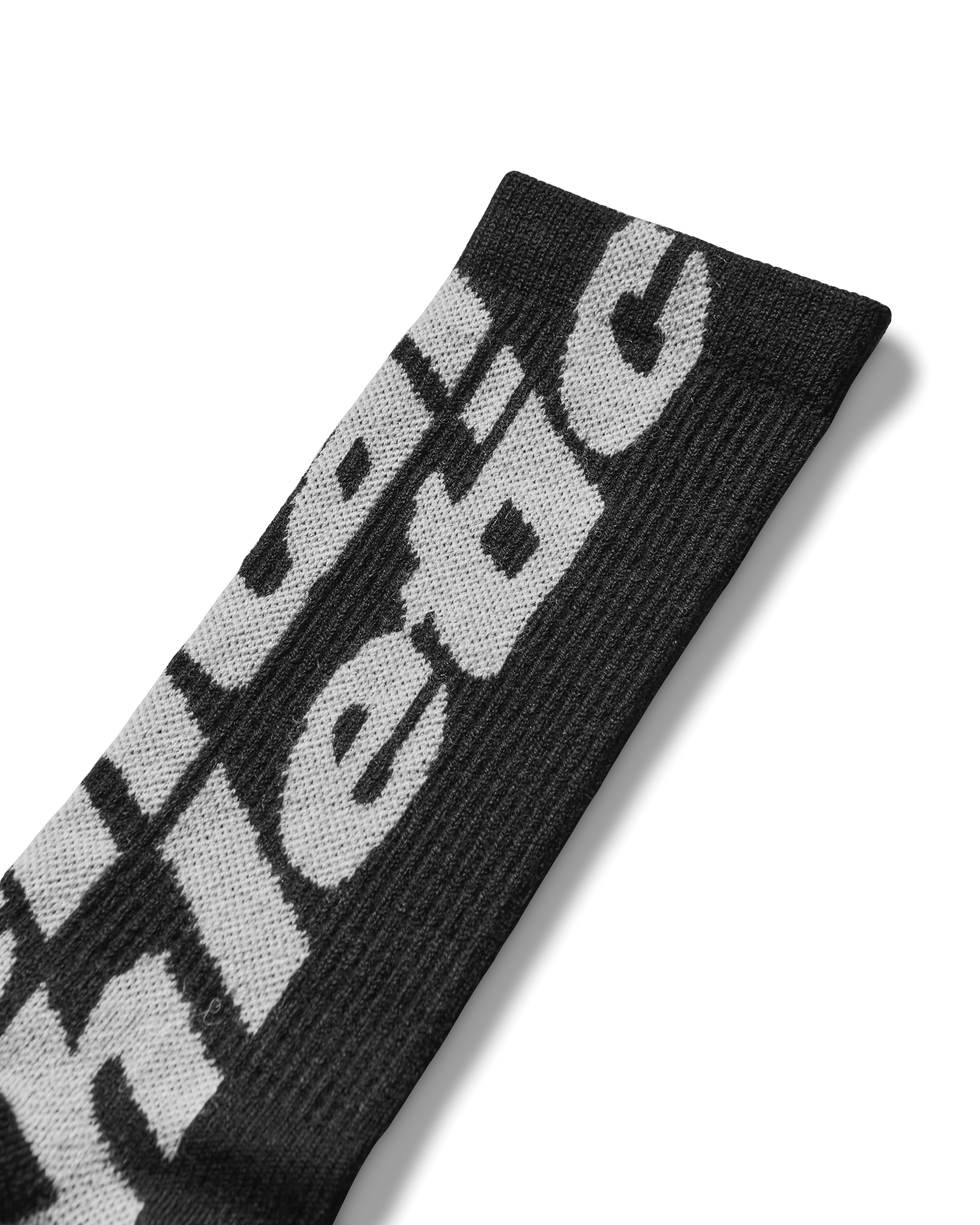 Logo close-up: Detail of woven blue Mental Athletic logo on textured wool fabric.