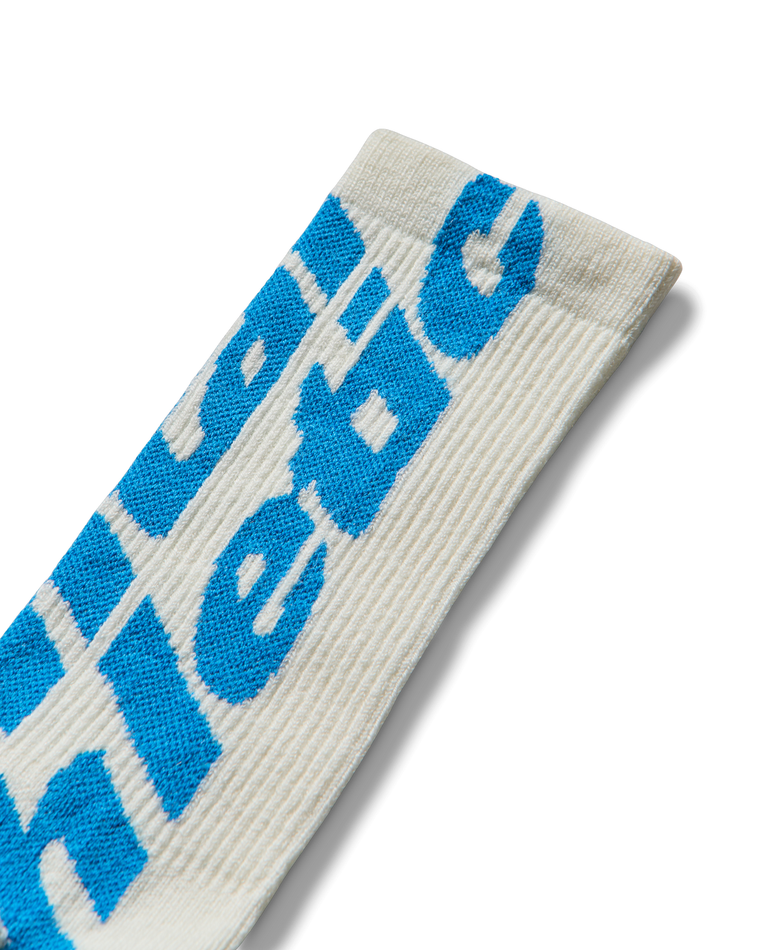 Logo close-up: Detail of woven blue Mental Athletic logo on textured wool fabric.