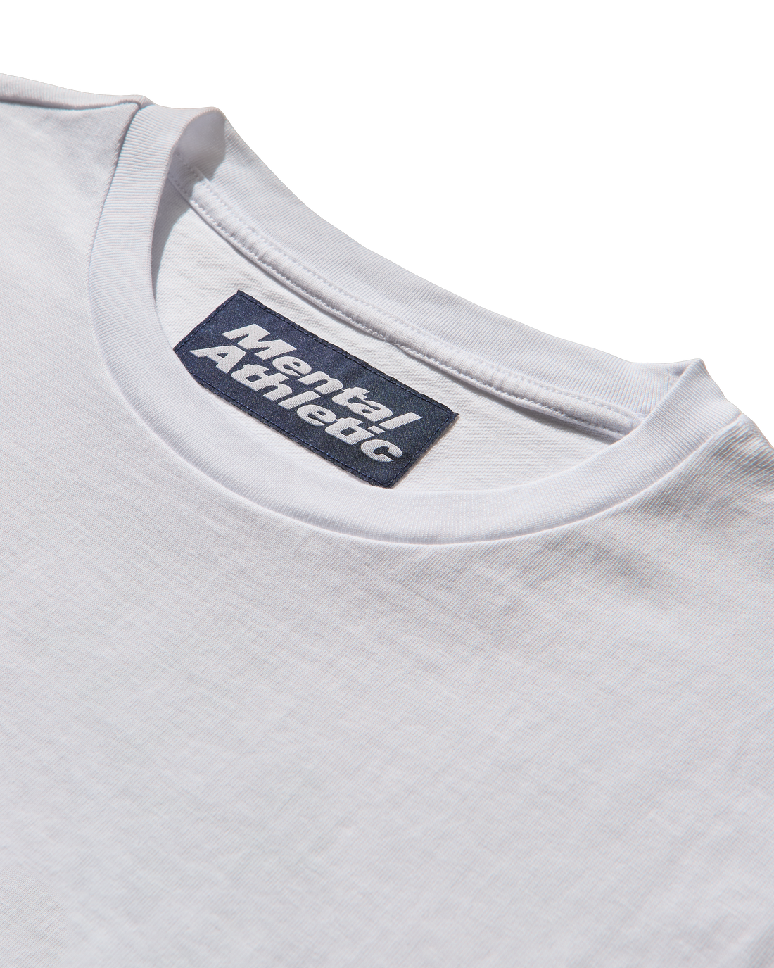 Close-up of a white t-shirt with 'Mental Athletic' label on a white background