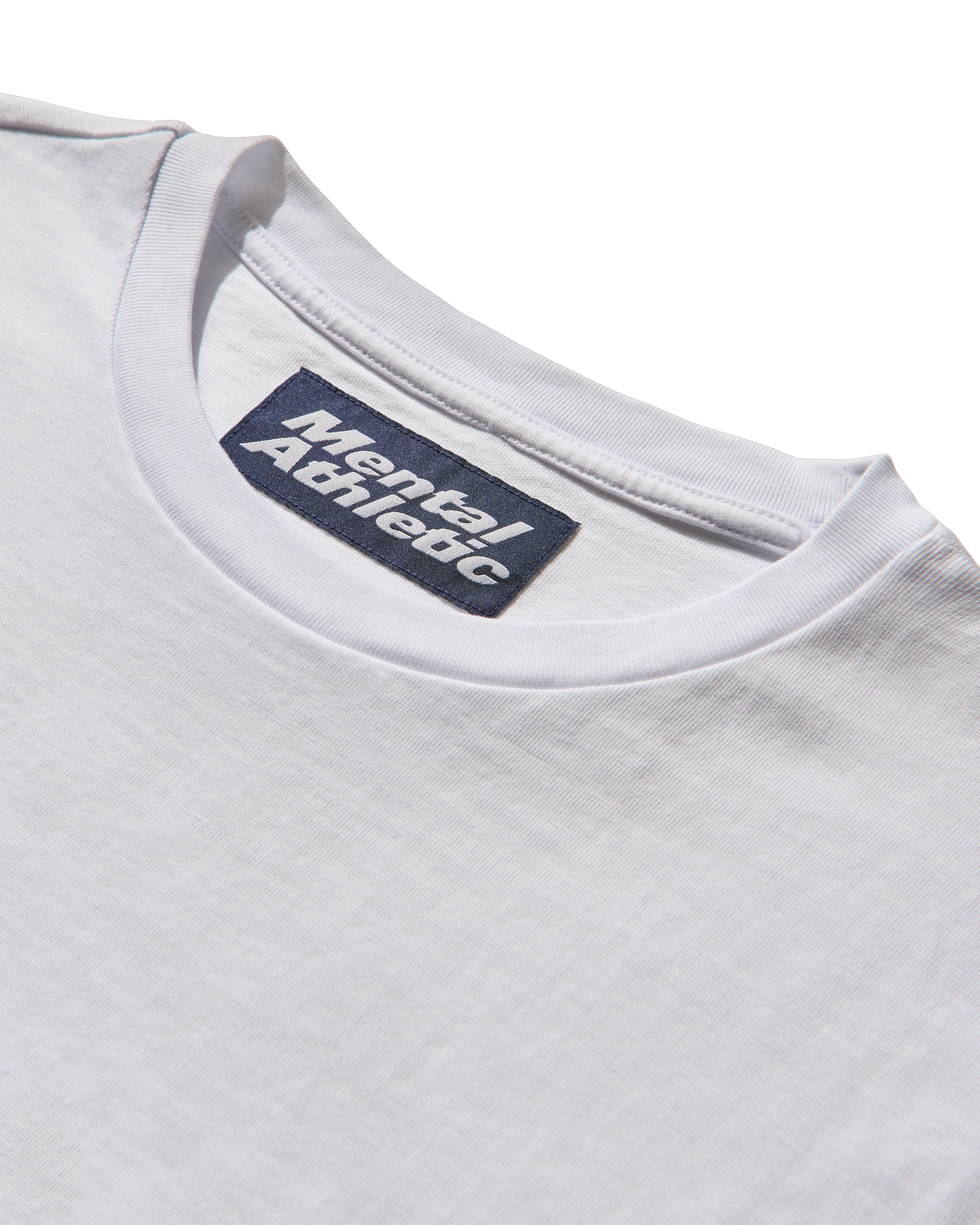 Close-up of a white t-shirt with 'Mental Athletic' label on a white background