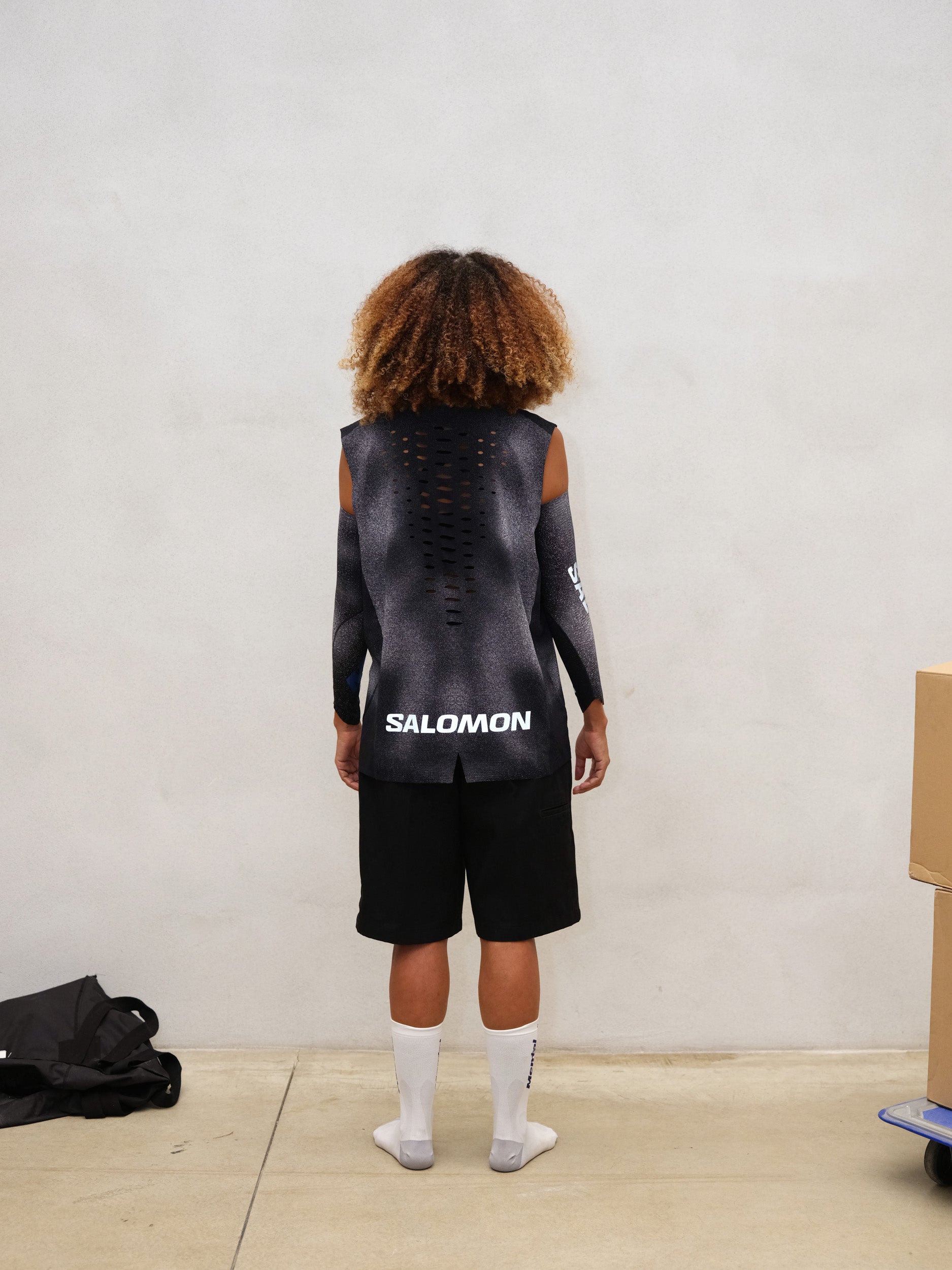 Back view of model wearing BACKBONE TANK U MENTAL ATHLETIC, ultralight trail top with laser-cut ventilation details