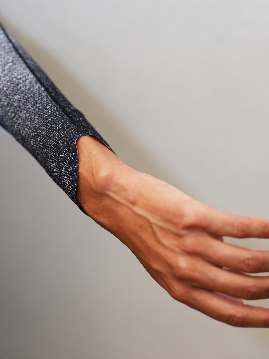 Side view detail of WIND RUSH ARM SLEEVES worn, lightweight compression fabric boosting circulation for trail running