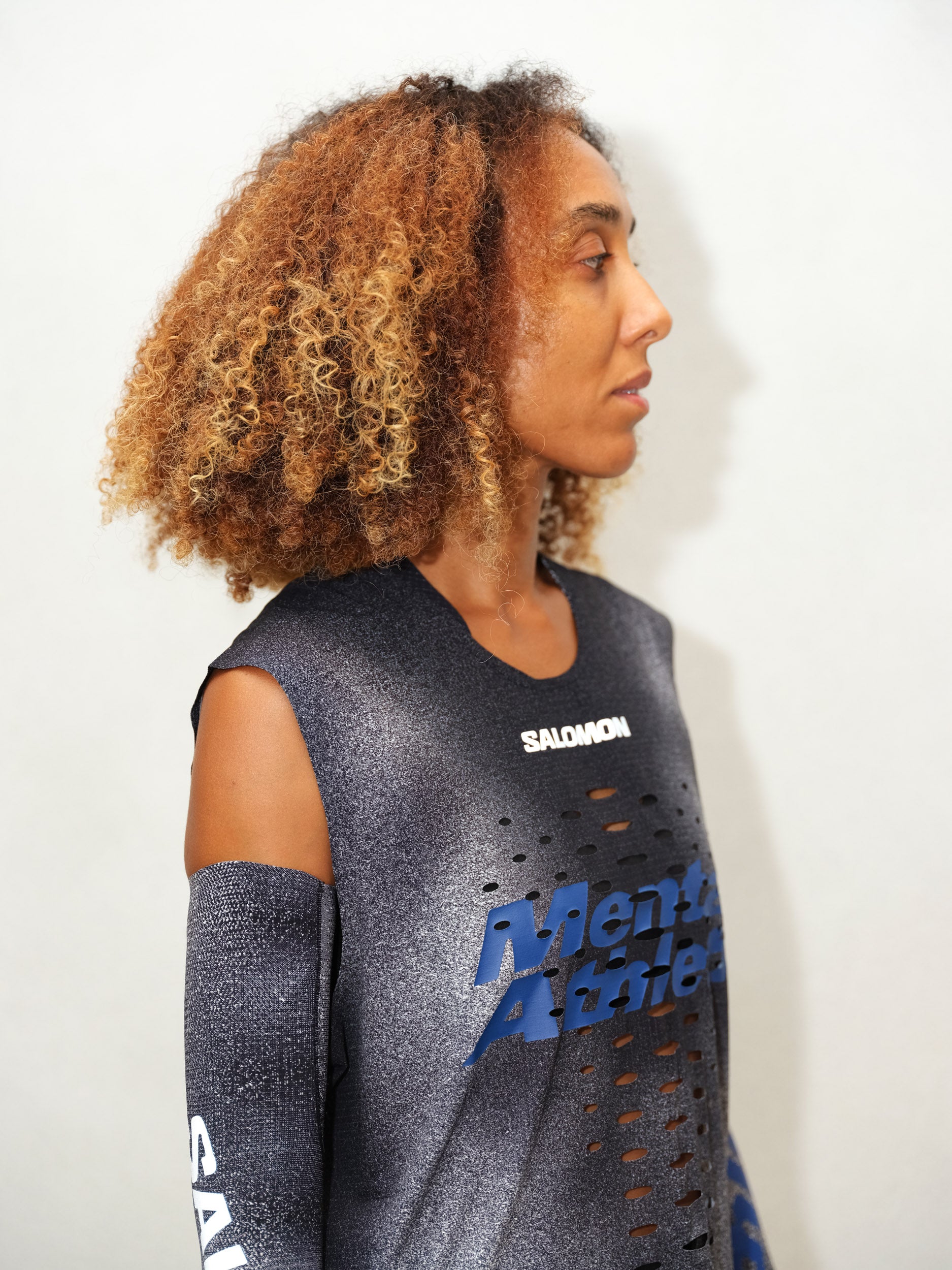 Profile portrait of model wearing BACKBONE TANK U LASER-ENGRAVED MENTAL ATHLETIC, lightweight trail running tank top with modern design