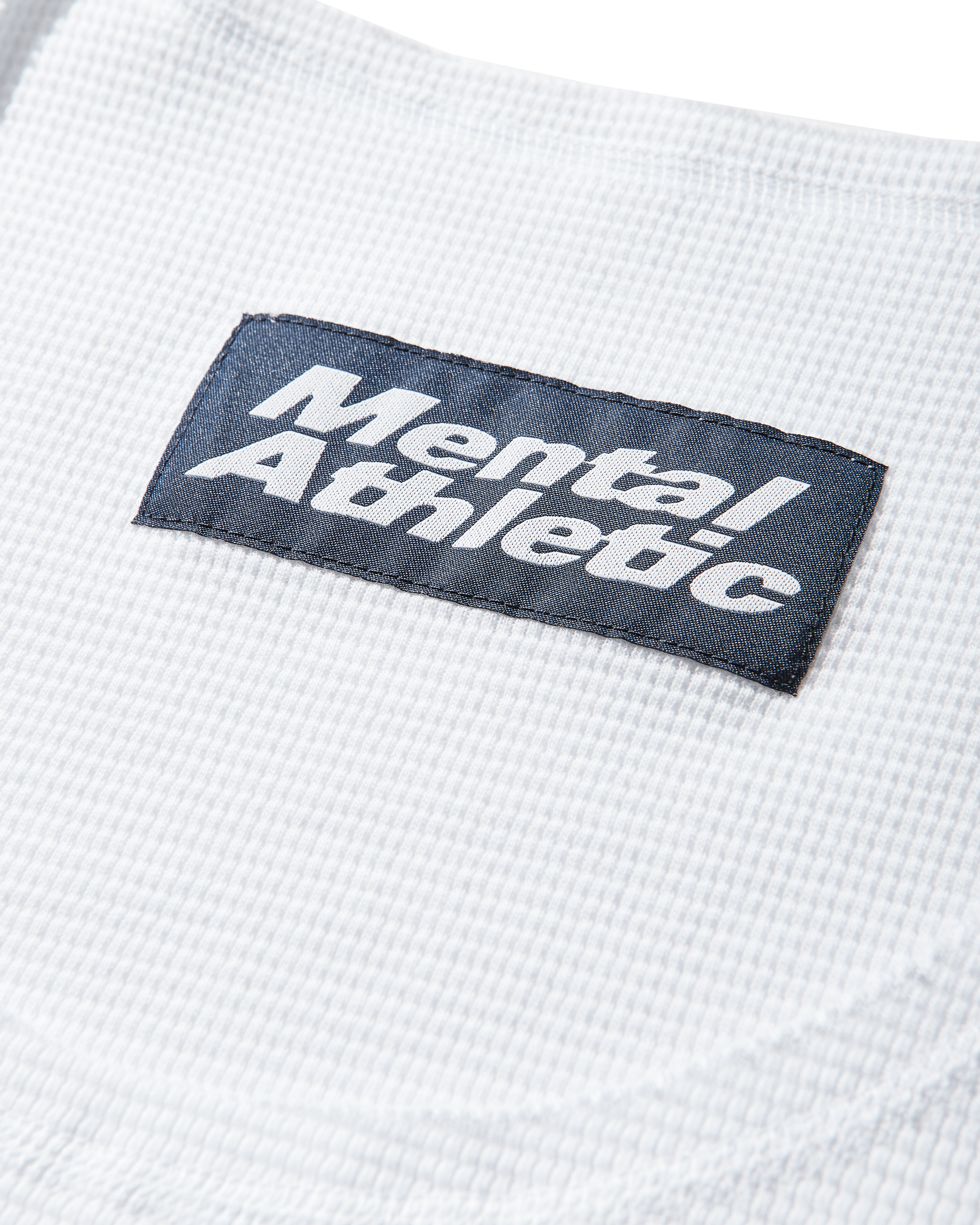 Mental Athletic white cotton tank top detail of waffle fabric and woven label.