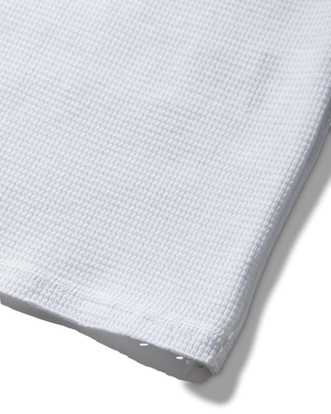 Mental Athletic white cotton tank top detail of raw-cut hem and textured fabric.