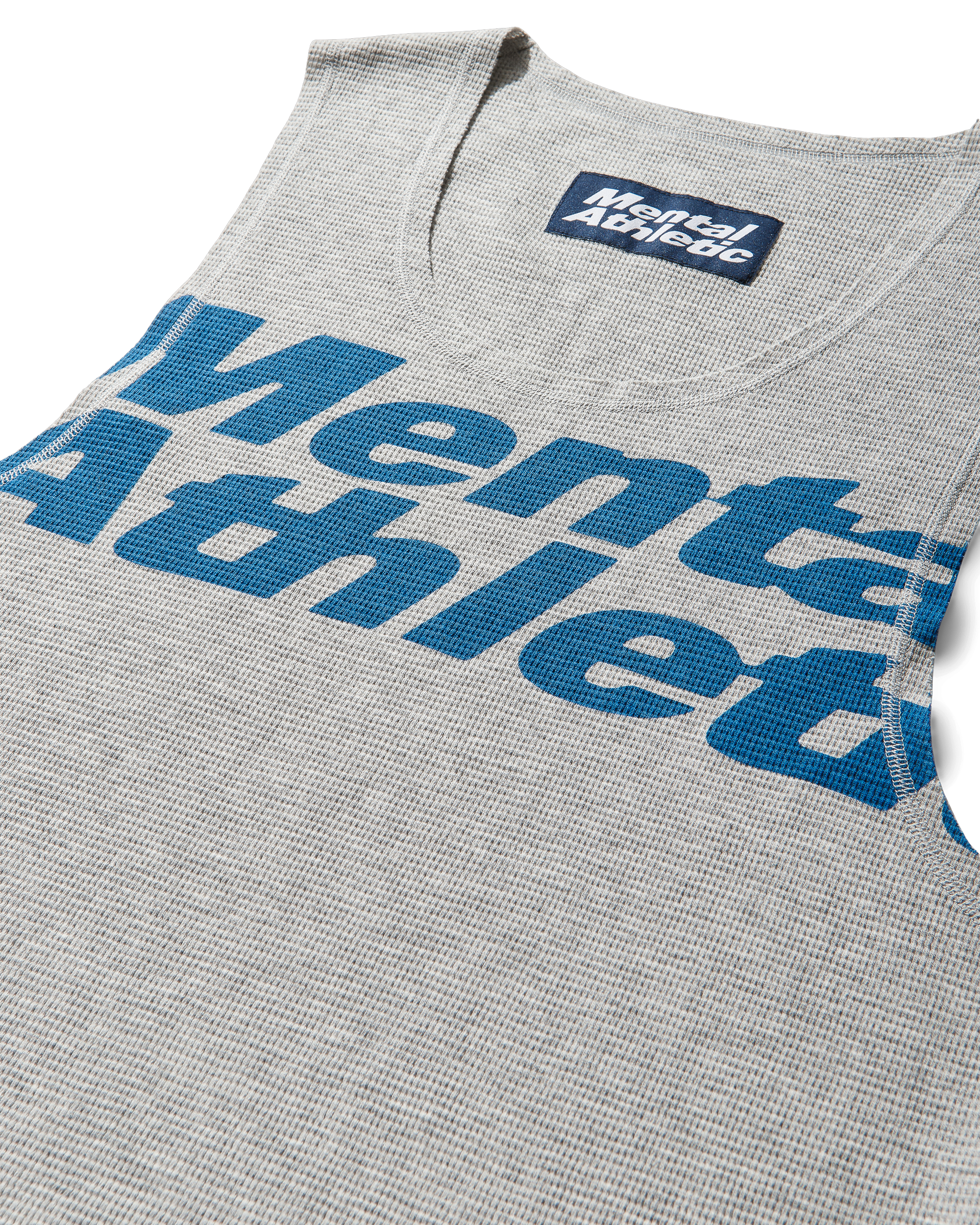 Mental Athletic grey cotton tank top close-up of blue overlogo print.