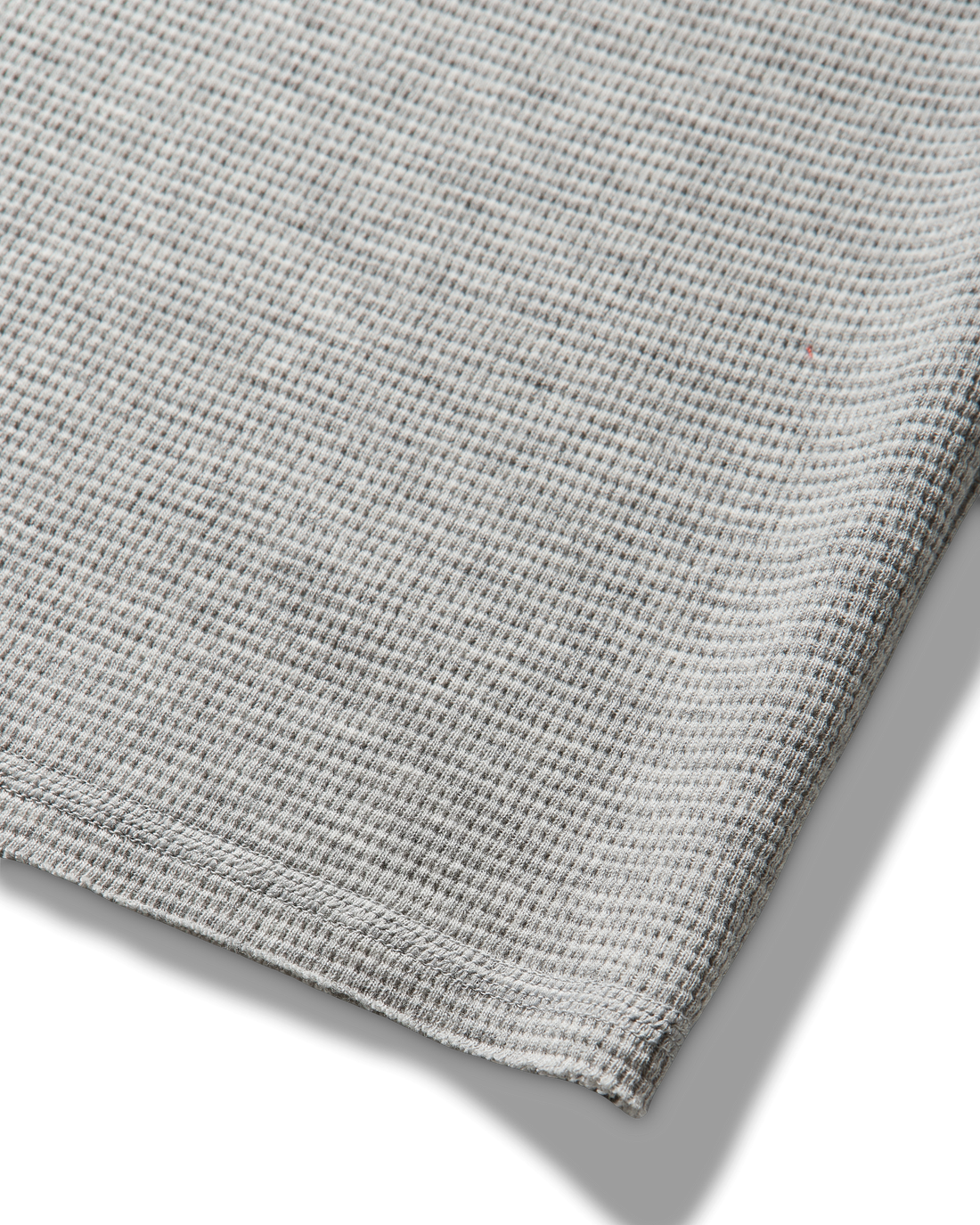 Mental Athletic grey cotton tank top detail of raw-cut hem and textured fabric.
