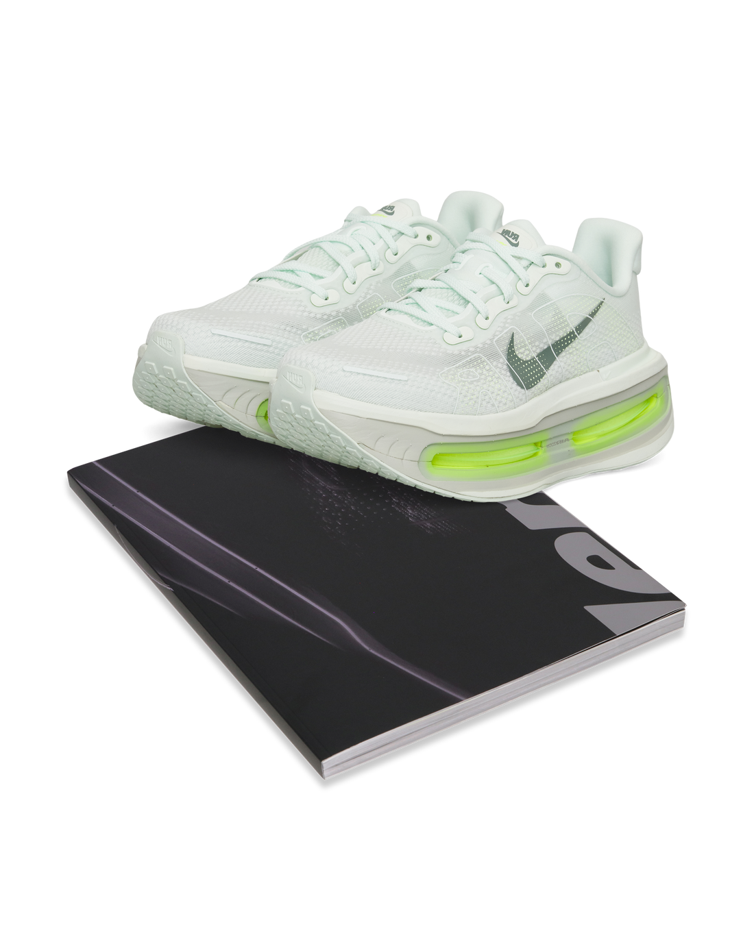 Full product composition: Nike Vomero Premium paired with Rise Above book.
