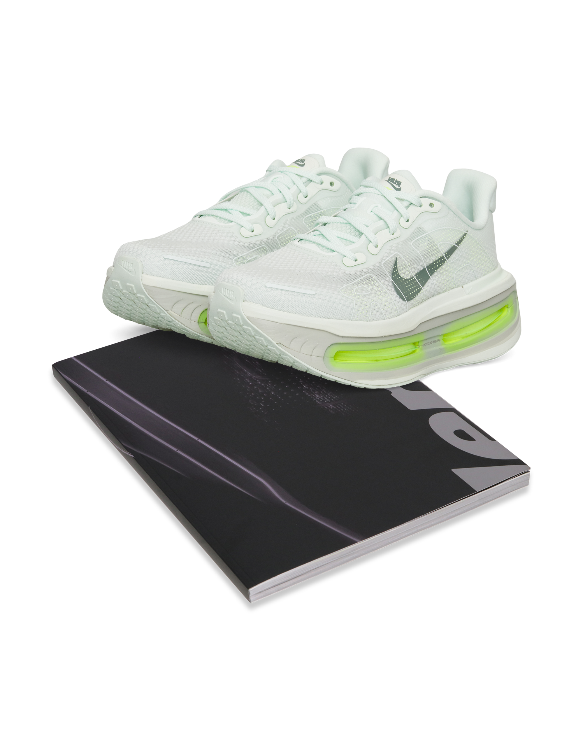 Full product composition: Nike Vomero Premium paired with Rise Above book.